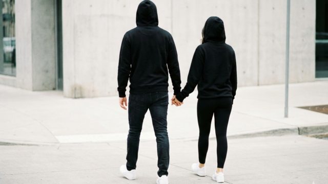 黒いパーカーと白スニーカーがお揃いのコーディネートのイメージ画像