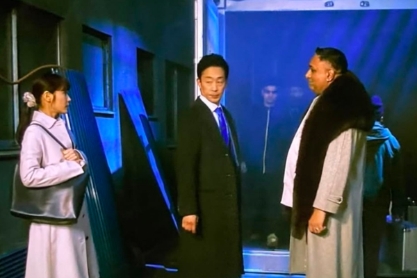 合六が大柄な外国人の男性と握手を交わすシーン画像